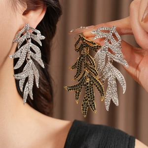 Detail of vintage leaf tassel earrings with rhinestones in silver and gold finishes
