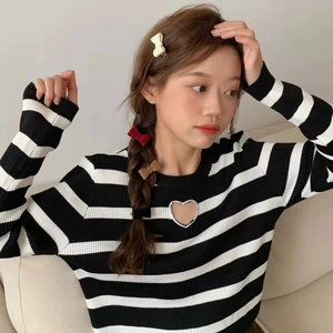 Détail du pull en tricot à rayures noires et blanches avec découpe en forme de cœur