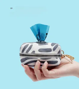 Canvas dog poop bag dispenser with pebble pattern and blue plastic waste bag extraction