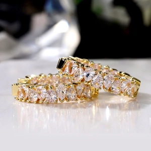 Macro detail of luxury gold-plated earrings with drop-shaped cubic zirconia in prong setting