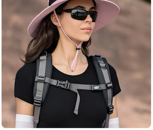 Cappello da sole outdoor a tesa larga rosa con occhiali sportivi e attrezzatura trekking