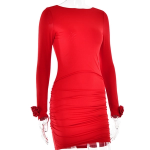Détail de la robe courte rouge moulante avec plis à la taille et fleurs aux manches