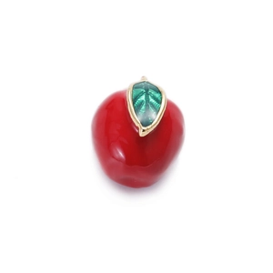 Macro shot of red apple enamel charm with green leaves and gold metal edges for DIY jewelry