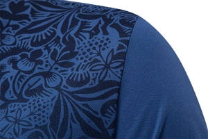 Macro shot of blue polo shirt showing premium knit fabric and floral print details