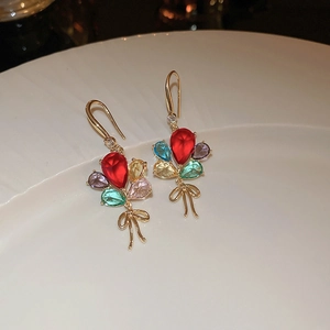Detailed close-up of colorful crystal balloon earrings with golden bow detail