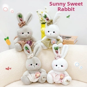 Detail of plush bunny dolls in floral dresses on a soft sofa with cozy home decor
