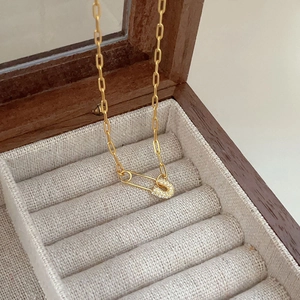 Detail of gold safety pin necklace with micro-pave crystals on paperclip chain
