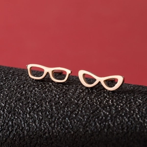 Minimalist rose gold sunglasses shaped stud earrings on black leather display