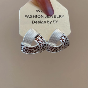 Detail of S925 silver stud earrings with triangle twist design and leopard pattern enamel