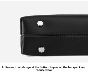 Detail view of the black shoulder bag bottom featuring two silver protective metal studs