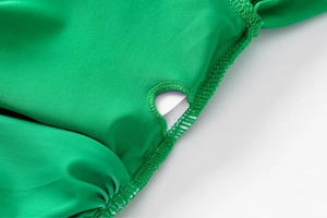 Detailed close-up of neon green swimwear fabric with reinforced stitching and ruffle trim