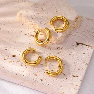 Classic 4mm thick gold stainless steel hoop earrings for women on a textured stone base