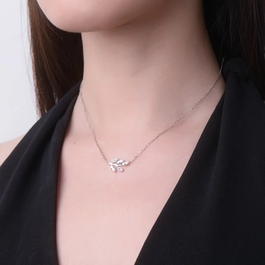 Detail of leaf pendant necklace featuring marquise cut D color moissanite on model