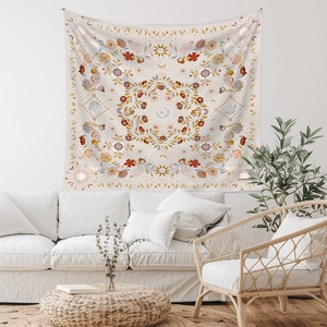 Detail of bohemian tapestry featuring sun and moon motifs with floral patterns on a wall