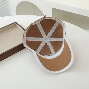 Detailed interior of children's cotton baseball cap with white piping and breathable vents