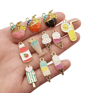 Detail view of ten colorful enamel summer drink and dessert alloy charms held in hand