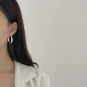 Polished S925 sterling silver hoop earrings shown on a model with minimalist style