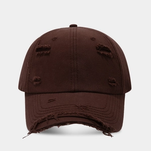 Macro detail of distressed ripped edges on a dark brown cotton baseball cap fabric