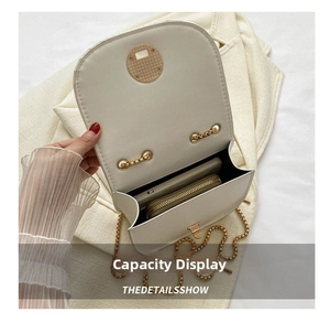 Detail view of the white crossbody saddle bag interior showing space for a phone and wallet