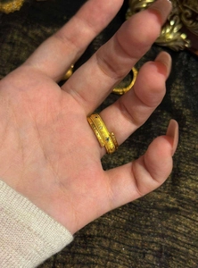 Macro view of vintage gold ring featuring engraved star sun patterns and tiny blue zircons