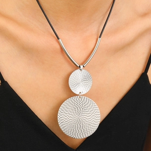 Detail of silver geometric double disc pendant with concentric ripple texture and black cord