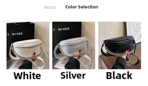 Close-up of saddle-style cross-body bags in white, silver, and black with chain detail