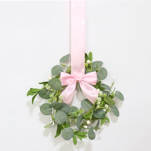 Pink satin ribbon bow hanging wreath with eucalyptus leaves and white berries decor