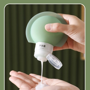 Close-up of green silicone squeeze bottle dispensing body wash for travel use