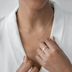 Close-up of a s925 sterling silver gold-plated necklace with an olive green zircon pendant