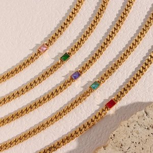 Golden 6.5mm Cuban link necklaces with rectangle colored zircons on beige background