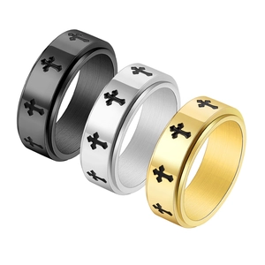 Detailed view of rotating cross rings in black, silver and gold brushed stainless steel