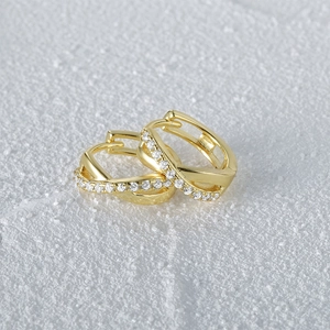 Macro shot of gold-plated S925 silver crisscross earrings with sparkling cubic zirconia