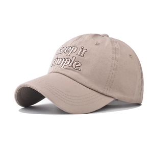 Detail of khaki cotton baseball cap showing 'keep it simple' 3D embroidery and twill texture