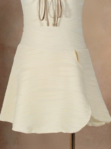 Close-up of cream knitted midi skirt with horizontal wave texture and side tie details