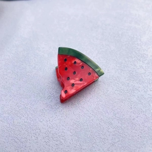 Close-up of watermelon-shaped acetate hair clip with realistic red and green textures