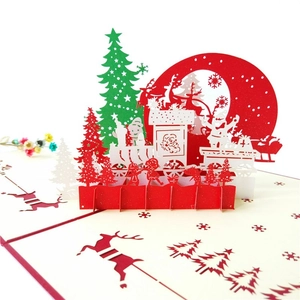 Close-up of 3D pop-up Christmas card featuring Santa Claus and reindeer on white background