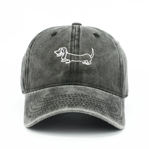Detail of white dachshund embroidery on dark grey washed cotton baseball cap texture