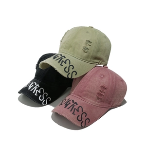 Three distressed baseball caps with Progress print on the brim in green, black, and pink