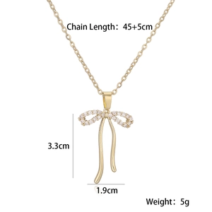 Macro shot showing 3.3cm x 1.9cm gold bow pendant size with white sparkling zircon inlay