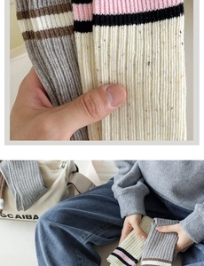 Dettaglio di calze in maglia a coste grigie e beige con puntini colorati e strisce