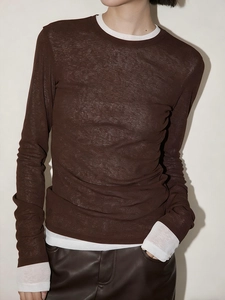 Detail of layered long-sleeve top with sheer brown texture over white base shirt