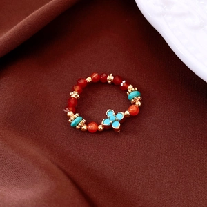 Macro view of vintage beaded ring with carnelian and turquoise flower on brown silk