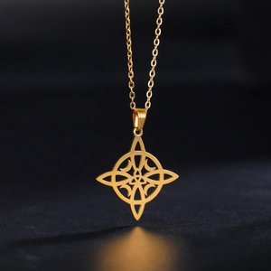 Gros plan d'un pendentif nœud celtique doré au design ajouré sur fond noir élégant