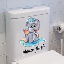 Close-up of elephant wall sticker with 'please flush' text on white bathroom toilet