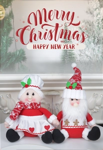 Gros plan de poupées Père Noël en peluche avec toques pour décoration de vitrine de Noël