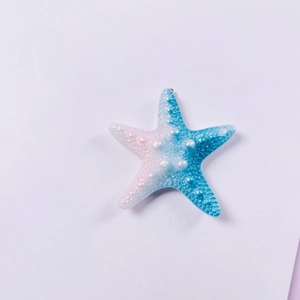 Detailed macro view of a resin starfish pendant with blue to white gradient texture