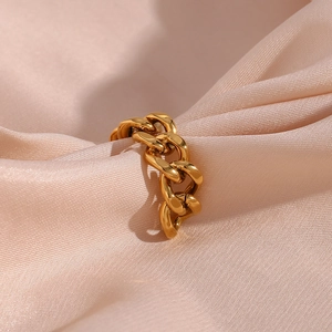 Gold stainless steel cuban chain weave open ring on elegant pink silk fabric background