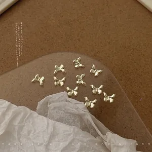 Detailed view of 20pcs 5x7mm mini golden alloy bow tie charms for nail art DIY
