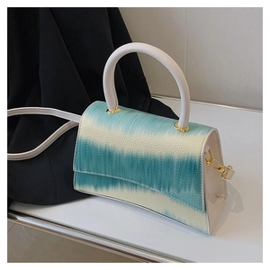 Detail shot of the blue and white tie-dye textured leather handbag with gold metal hooks