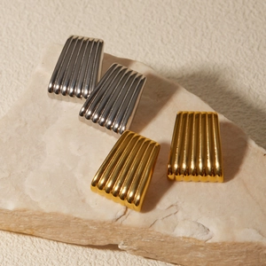 Classic 18k gold and silver ribbed trapezoid earrings on a minimalist stone base